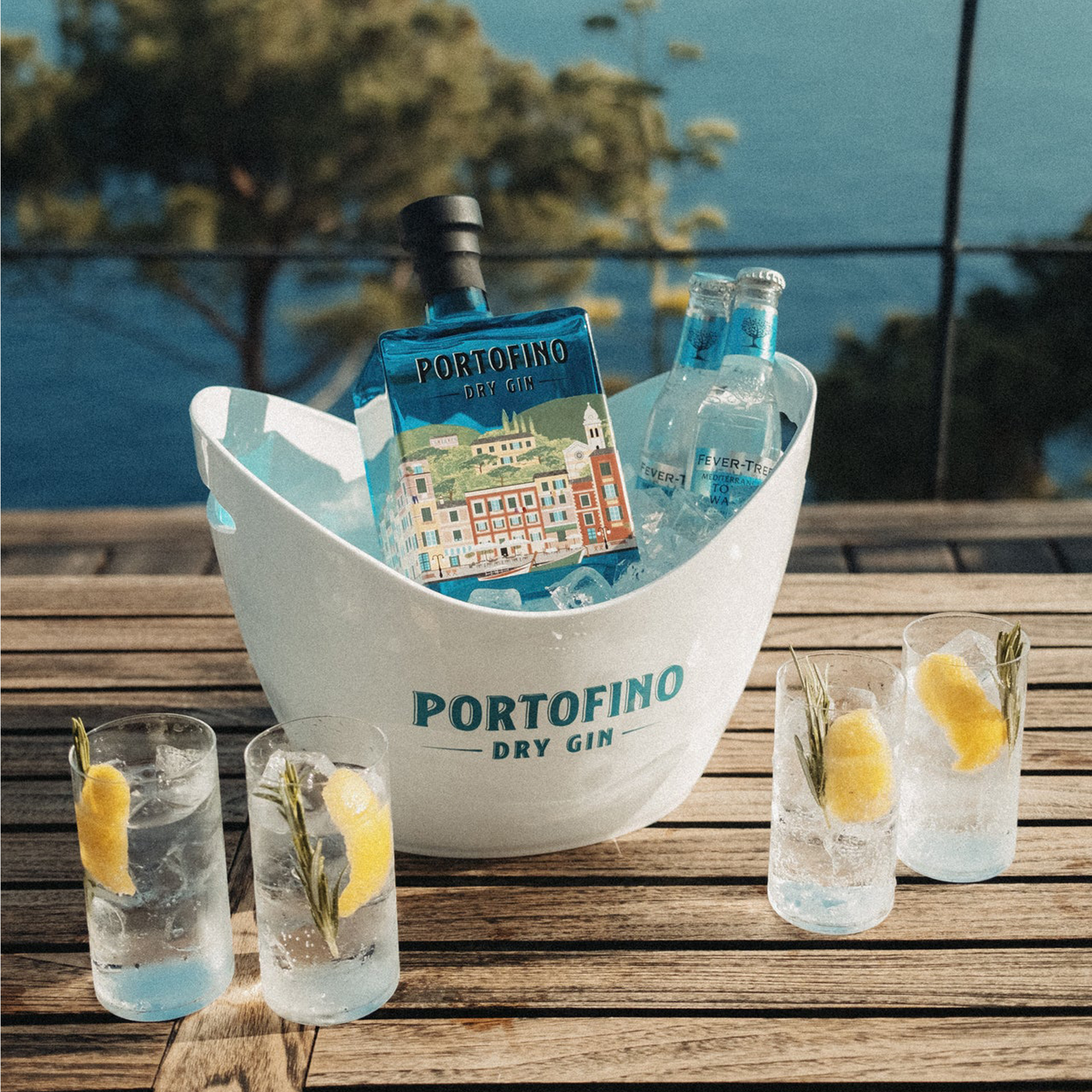 Butelka ginu Portofino Dry Gin wraz z tonikiem w coolerze Portofino