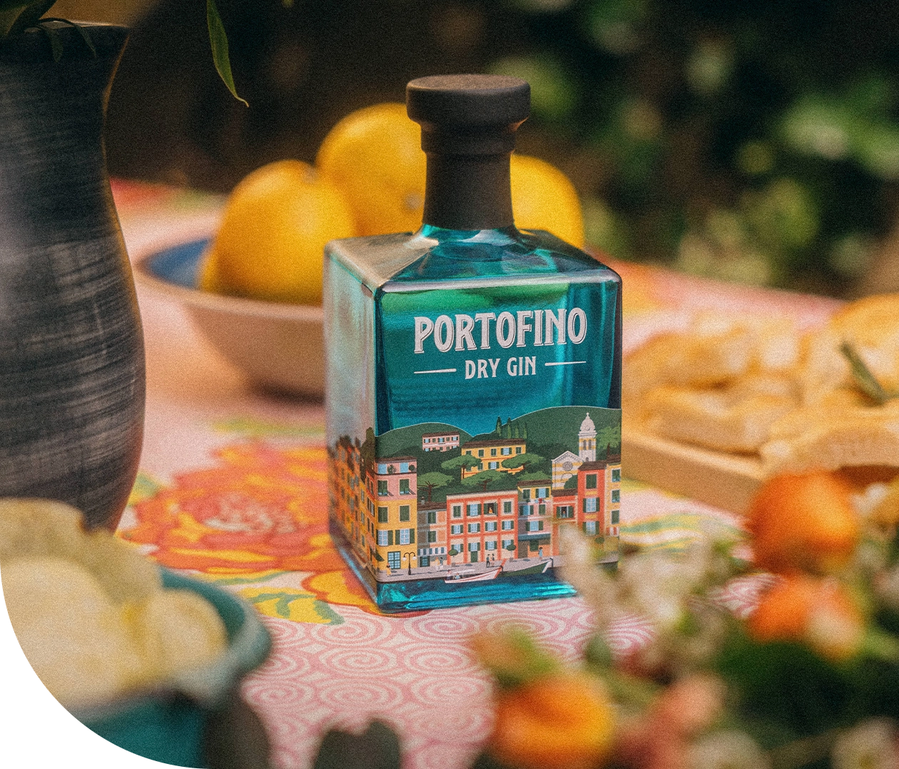butelka portofino dry gin na stole w otoczeniu cytryn i przekąsek