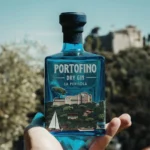 Dłoń trzymająca butelkę ginu Portofino Dry Gin La Penisola