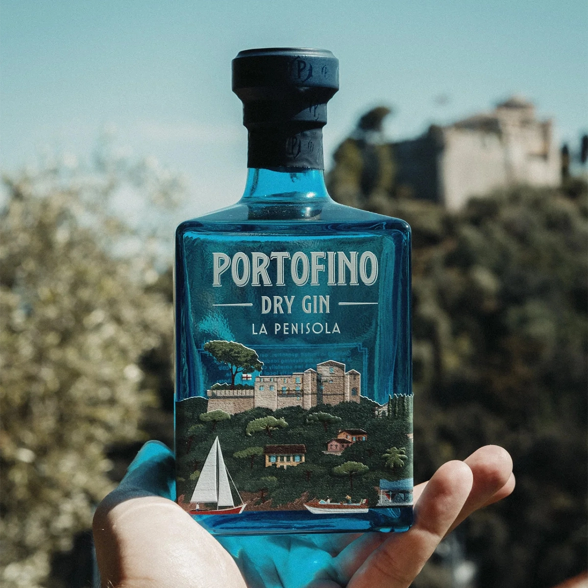 Dłoń trzymająca butelkę ginu Portofino Dry Gin La Penisola