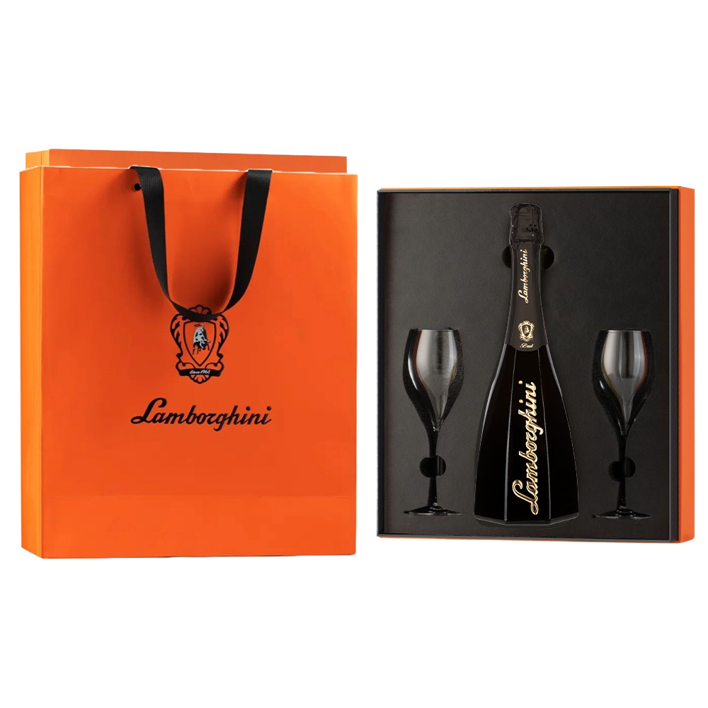 A black, octagonal bottle of Lamborghini Ottagonale Brut wine with gold details and two glasses packed in an orange gift box next to a branded gift bag on a black background.