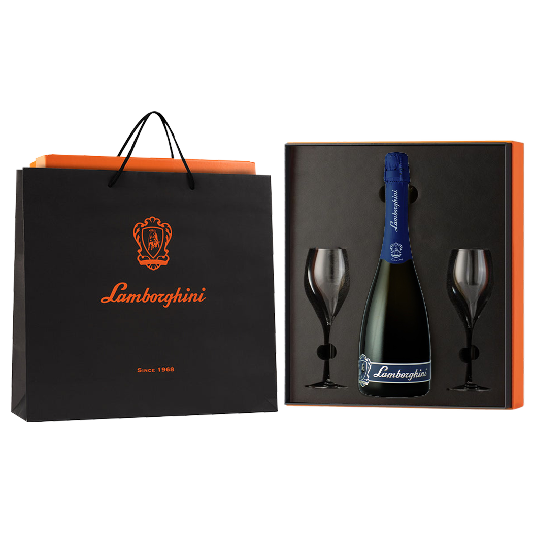 A dark bottle of Lamborghini Extra Dry Vino Spumante wine with a blue label and two glasses in a luxury orange gift box next to a Lamborghini gift bag on a black background.