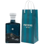 Prawy bok butelki Portofino Dry Gin Winter Nights 500 ml ze srebrnym księżycem i łodzią, obok granatowa torba firmowa