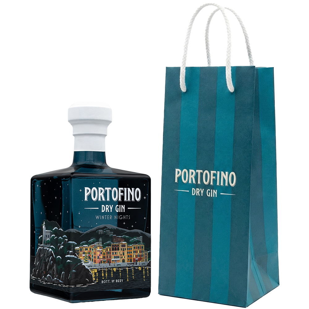 Portofino Dry Gin Winter Nights Limited Edition 500 ml z granatową torbą Portofino, butelka pod kątem z ilustracją zimowego wybrzeża.